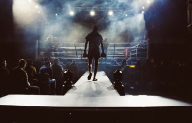 man standing and walking going on boxing ring surrounded with people
